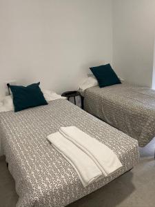 2 camas con toallas en una habitación en Hostal La Masia, en Manresa