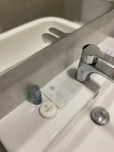 a bathroom sink with a bottle of soap on it at Hostal La Masia in Manresa