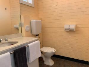 a bathroom with a toilet and a sink with towels at Wedderburn Goldseeker Motel in Wedderburn