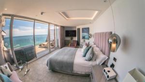 a bedroom with a large bed with a view of the ocean at The Pines Hotel in Swanage