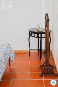Quinta do Monte Bravo - DOURO - Quarto Duplo في Ervedosa do Douro: طاولة وكرسي بجانب طاولة