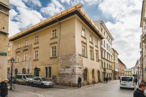 a building on a street with cars parked on the street at Szpitalna 9 Residence in Kraków