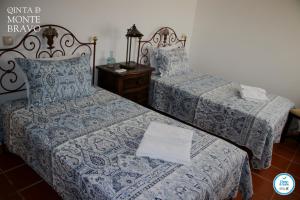a bedroom with two beds with blue and white sheets at Quinta do Monte Bravo - DOURO - Quarto Duplo in Ervedosa do Douro