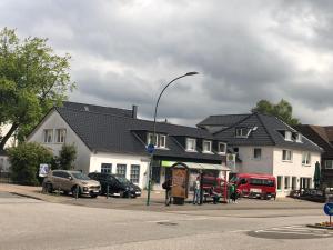una luz de la calle con coches estacionados frente a un edificio en Apartment AMS, en Oststeinbek