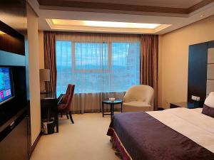 a hotel room with a bed and a large window at Yi Mei Plaza Hotel in Yiwu