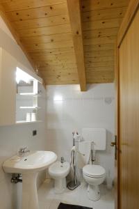 a white bathroom with a sink and a toilet at Residenza Mariella in Arco