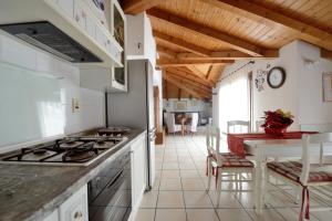 a kitchen with a stove and a table with chairs at Residenza Mariella in Arco