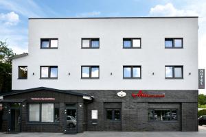 Ata Hotel - Self Check-in في هامبورغ: مبنى أبيض كبير مع واجهة متجر