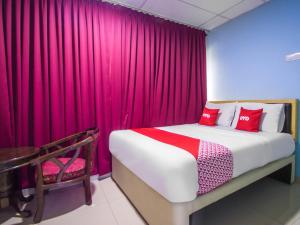 a bedroom with a bed and a red curtain at OYO 89842 Hotel 22, Northport in Klang
