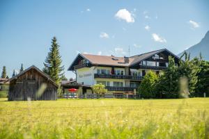 ein großes Haus mit einem Feld davor in der Unterkunft Ferienappartements Annemarie in Oberstdorf