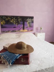 um chapéu está sentado em cima de uma cama em casa per l'osticcio vista sulla val d'orcia em Montalcino