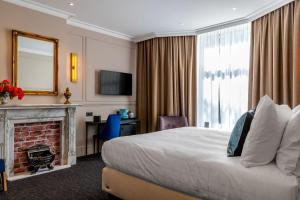 a hotel room with a bed and a fireplace at De Ware Jacob Boutique Hotel in Amsterdam