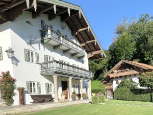 un gran edificio blanco con balcón. en Auszeit im Chiemgau, Ferienwohnungen en Rottau