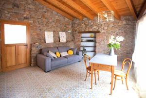 - un salon avec un canapé, une table et des chaises dans l'établissement El Mas de Sant Vicenç - apartamentos rurales, à Arsèguel