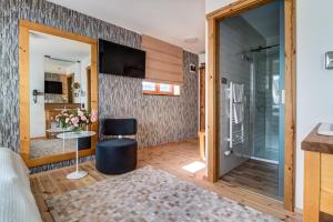 a room with a shower and a glass door at Hotel Na Rozcestí in Čeladná