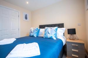 a bedroom with a bed with blue and white pillows at Apartment 9 in Worksop