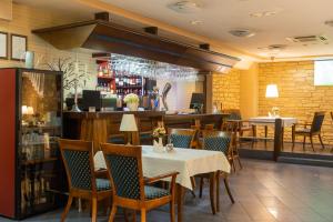 a restaurant with a table and chairs and a bar at Hotel Vaidila in Alytus