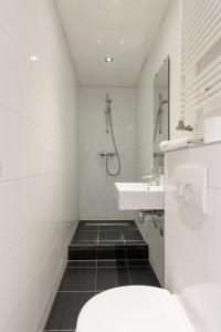 a white bathroom with a sink and a toilet at Spacious apartment in city center with private patio in Amsterdam