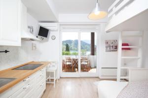 a kitchen with white cabinets and a dining room at Lakefront Bled - Rooms & Apartments in Bled