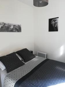 um quarto com uma cama com um edredão preto e branco em Les Néréides em Mers-les-Bains