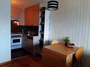 a kitchen with a wooden table with a bowl of fruit on it at The fox's family home - Veysonnaz in Veysonnaz