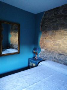 a bedroom with a bed and a mirror on the wall at Casa Rural Calecha in Caboalles de Abajo