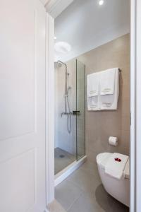 a bathroom with a shower and a white toilet at Viaggio Elegant Rooms in Chania Town