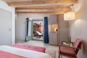 a bedroom with a bed and a table and a chair at Viaggio Elegant Rooms in Chania Town