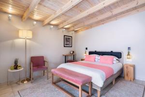 a bedroom with a large bed and a chair at Viaggio Elegant Rooms in Chania