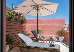 a patio with an umbrella and a table and chairs at Viaggio Elegant Rooms in Chania Town