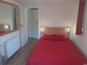 - une chambre avec un lit rouge et 2 oreillers rouges dans l'établissement Appartement les Acacias, à Clamart