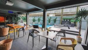 a restaurant with tables and chairs and a pool at Hotel Ordinary Bangkok in Bangkok
