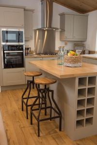 a kitchen with a counter and stools in a kitchen at Hollicarrs - Forest Retreat in York