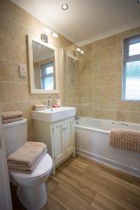 a bathroom with a toilet and a sink and a tub at Hollicarrs - Forest Retreat in York