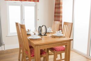 a wooden dining room table with chairs and a mirror at Hollicarrs - Forest Retreat in York