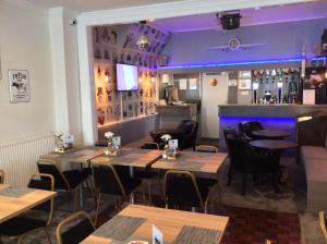 a restaurant with tables and chairs and a bar at Brene Hotel in Blackpool