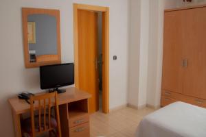 a bedroom with a television and a bed at Hostal Meseguer in El Alted