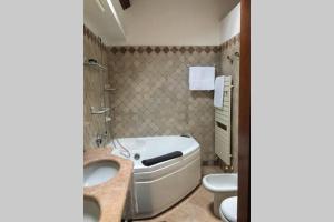 ein Badezimmer mit einer Badewanne, einem WC und einem Waschbecken in der Unterkunft Attico Baggio in Bassano del Grappa
