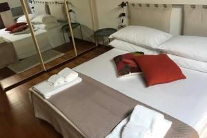 a hotel room with two beds and a mirror at Attico Baggio in Bassano del Grappa