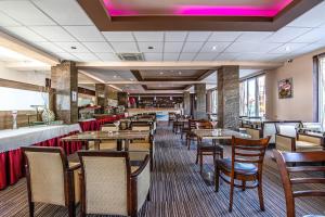 a restaurant with tables and chairs and a bar at Hotel Sun in Senec