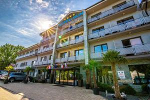 een hotelgebouw met palmbomen ervoor bij Hotel Sun in Senec