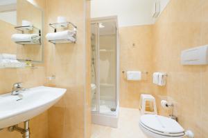 e bagno con servizi igienici, lavandino e doccia. di Hotel Puccini a Montecatini Terme