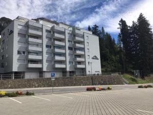 un grande edificio con un parcheggio antistante di Chesa Gravas a Lenzerheide