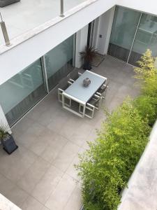 - une terrasse avec une table et des chaises blanches dans un bâtiment dans l'établissement Slow House d'Arco, à São Brás de Alportel