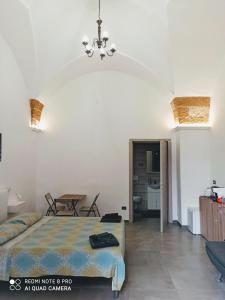 1 dormitorio con 1 cama, mesa y sillas en Monolocale Central Station, en Brindisi