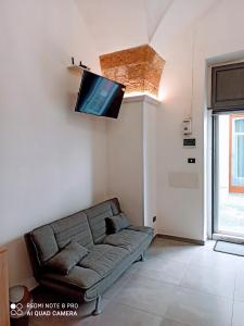 uma sala de estar com um sofá e uma televisão de ecrã plano em Monolocale Central Station em Brindisi
