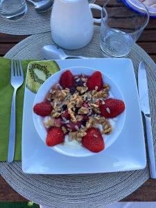 a bowl of cereal with strawberries and nuts on a table at Slow house d'encosta in São Brás de Alportel