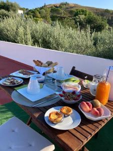 uma mesa de madeira com pratos de comida em Slow house d'encosta em São Brás de Alportel