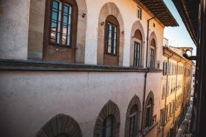 un callejón en un edificio antiguo con ventanas en Acacia Firenze - Melissa, en Florencia