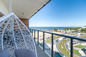 a room with a balcony with a view of the beach at Family Holiday Apartment Aquamarina Prima by Renters in Międzyzdroje